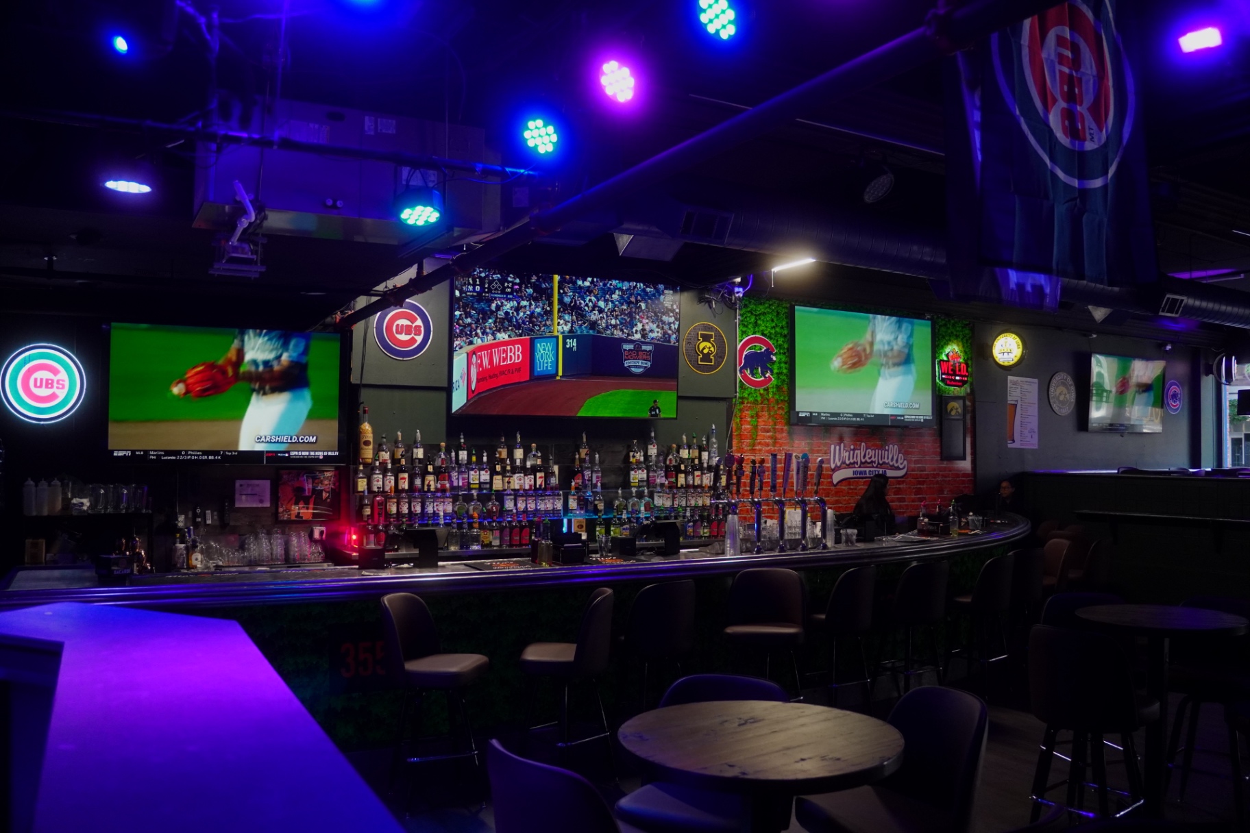 Wall of HDTVs behind the main bar showing Cubs baseball